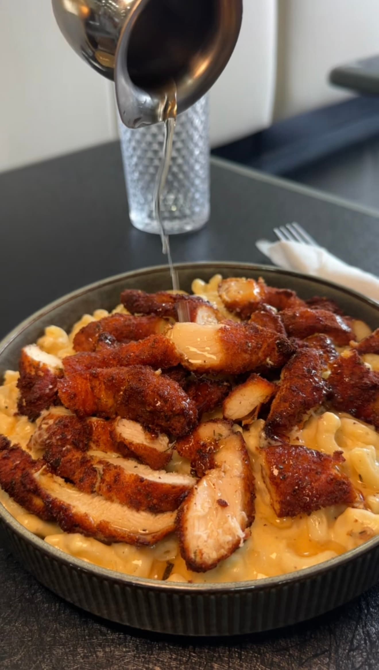 Honey chicken strips piled over creamy mac and cheese