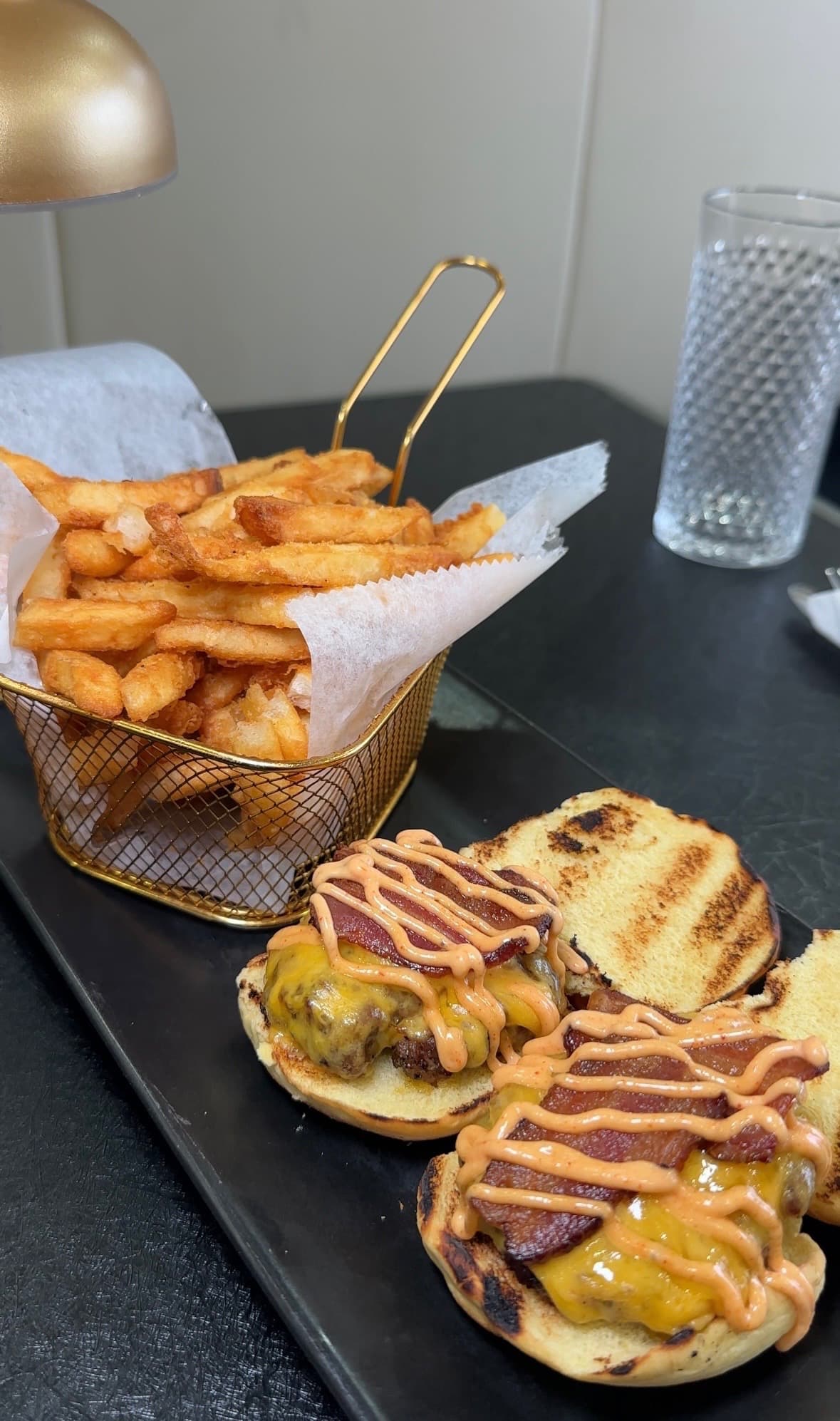 Two beef sliders with melted cheddar and bacon